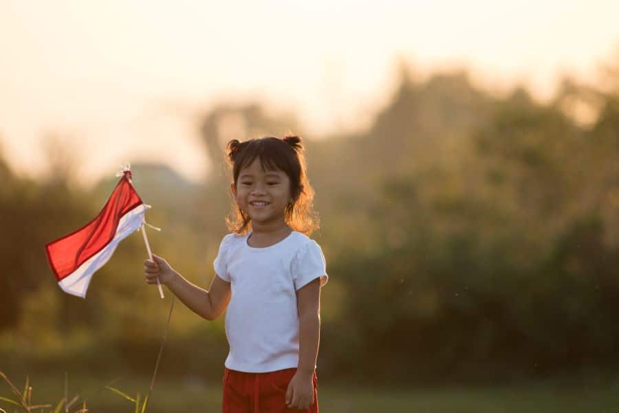 Young girl holding flag outdoors, playing capture the flag game