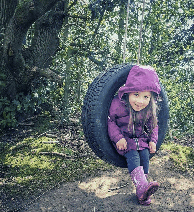 A girl rotating in a tire swing
