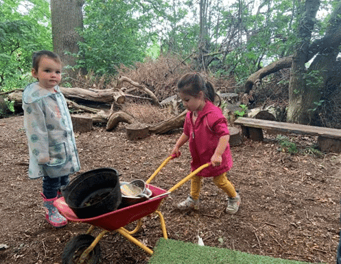Children with transporting schema using wheelbarrow